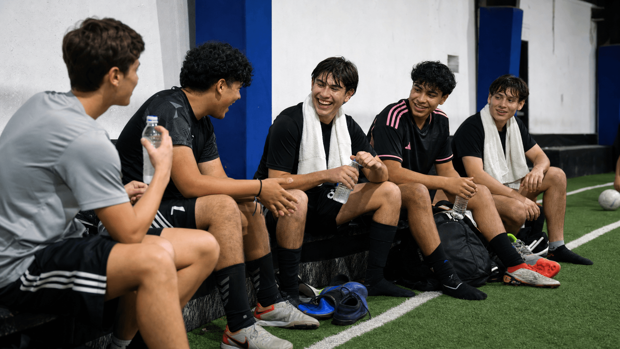 Players laughing on the sideline between sessions